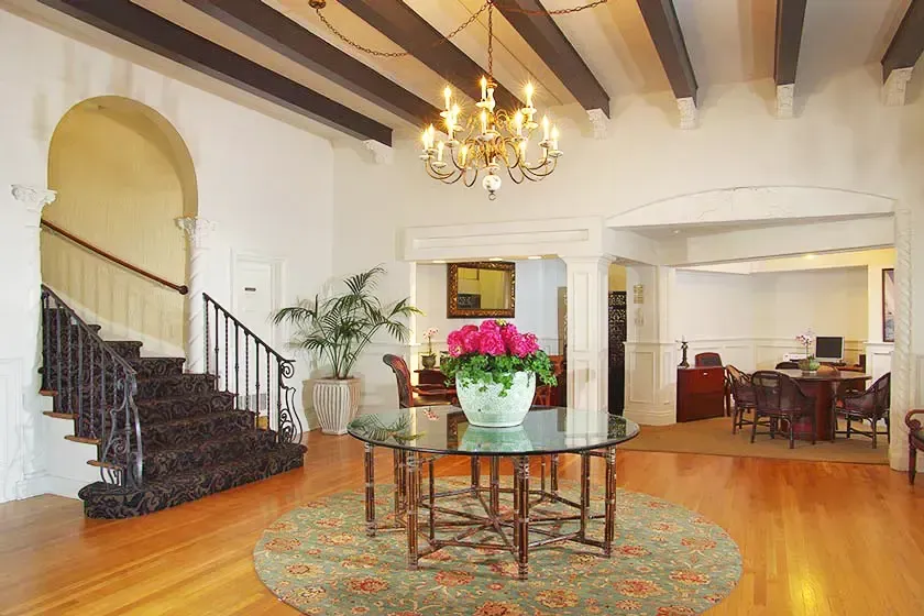 Foyer of the historic building with a staircase and chandelier