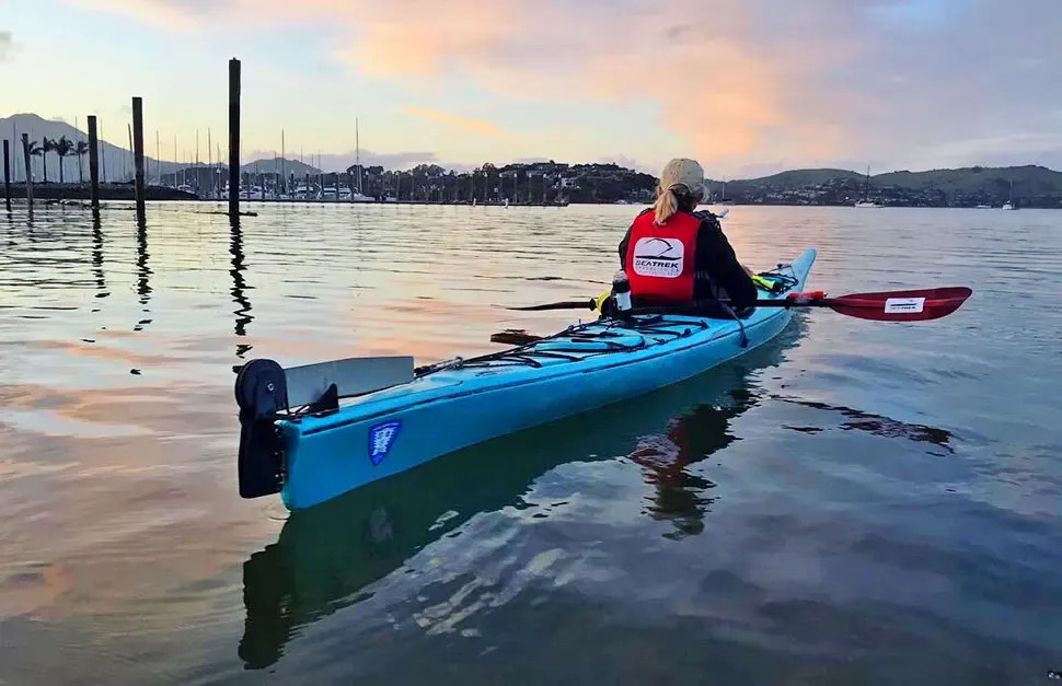 A kayaker paddling on Richardson Bay at sunrise, seen from behind